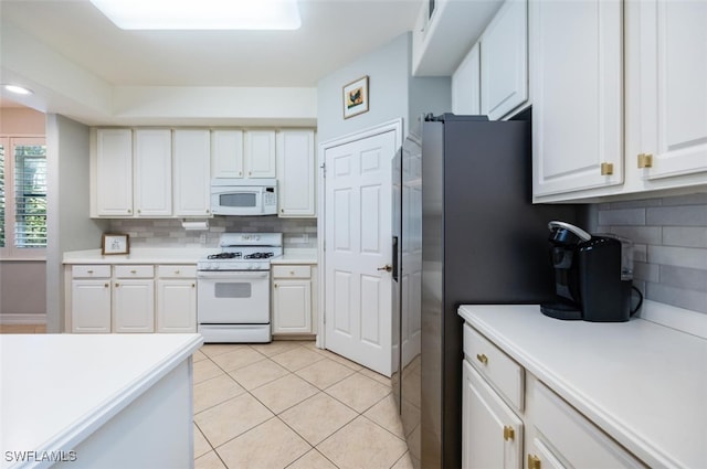 kitchen featuring light tile patterned floors, light countertops, white appliances, and white cabinets