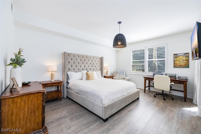 bedroom with light wood finished floors and baseboards