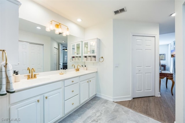 bathroom featuring double vanity, a closet, visible vents, and a sink