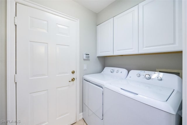 clothes washing area with cabinet space and washer and clothes dryer