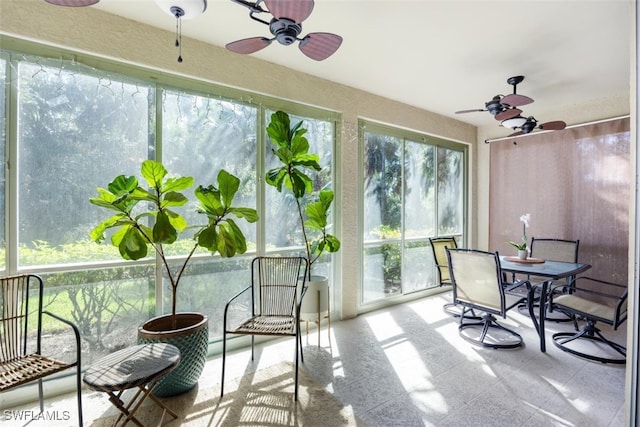 sunroom / solarium featuring a ceiling fan