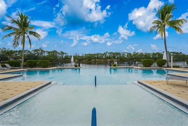 community pool with a patio area and fence