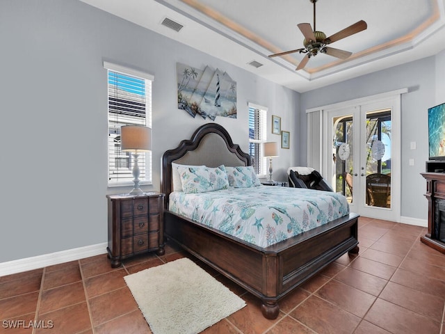 tiled bedroom with a raised ceiling, ceiling fan, access to exterior, and french doors