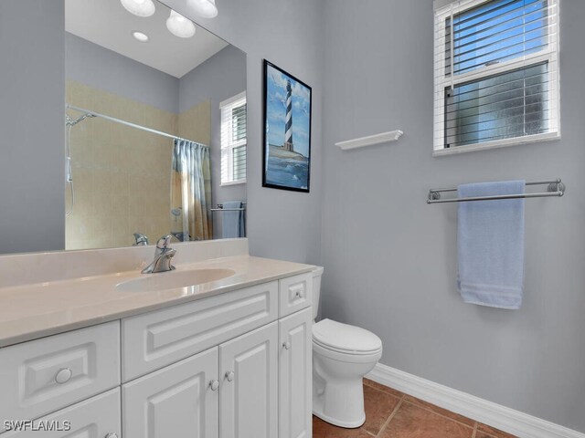 bathroom with tile patterned floors, a shower with curtain, vanity, and toilet