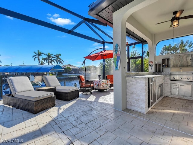 view of patio featuring glass enclosure, a water view, area for grilling, ceiling fan, and a grill