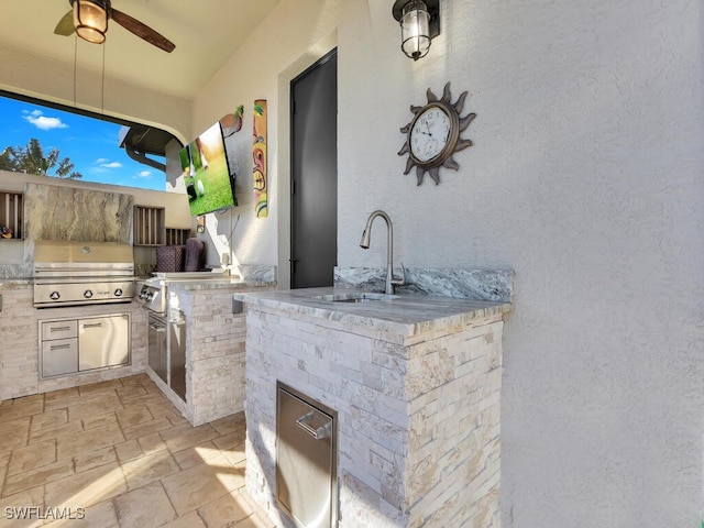 view of patio featuring ceiling fan, area for grilling, sink, and grilling area