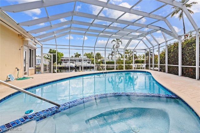 view of pool featuring a lanai, a patio area, and a water view