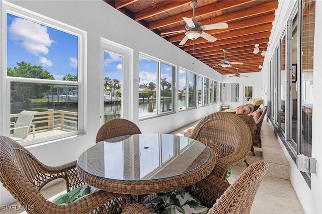 sunroom featuring ceiling fan, beamed ceiling, a water view, and wood ceiling