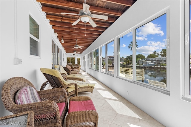 sunroom with vaulted ceiling with beams, a water view, and wood ceiling