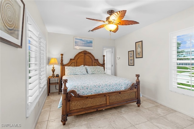 bedroom with ceiling fan, light tile patterned flooring, and multiple windows