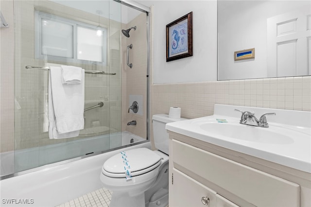 full bathroom with tile patterned flooring, enclosed tub / shower combo, toilet, vanity, and tile walls