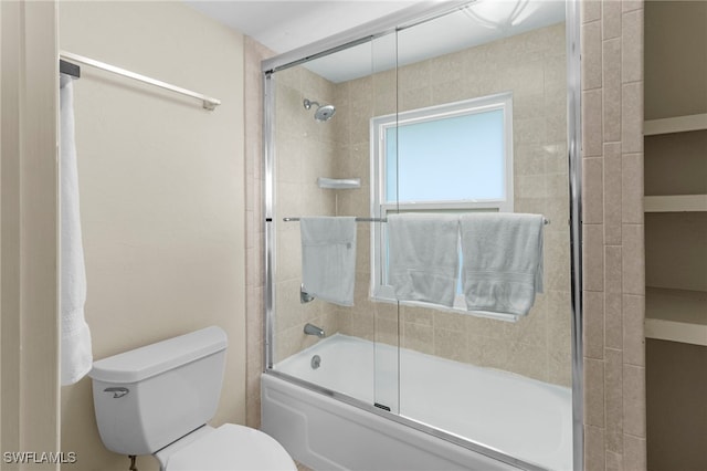 bathroom with bath / shower combo with glass door and toilet