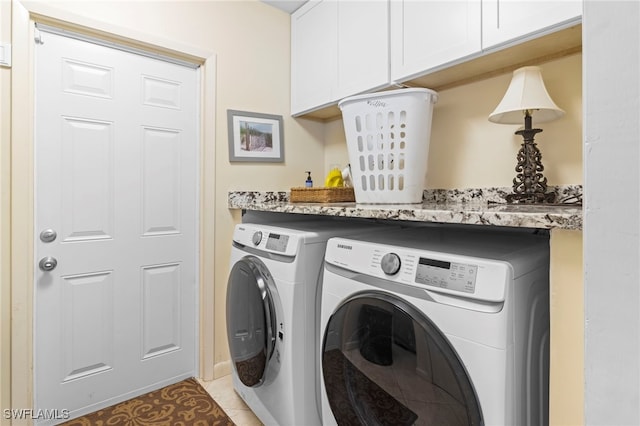 laundry area with washer and clothes dryer, light tile patterned floors, and cabinets