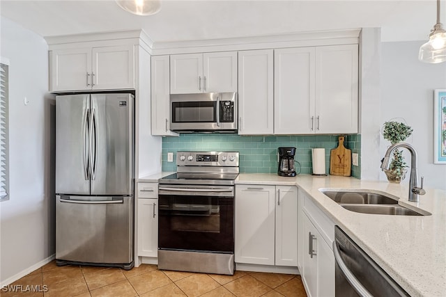 kitchen with stainless steel appliances, white cabinetry, hanging light fixtures, and sink