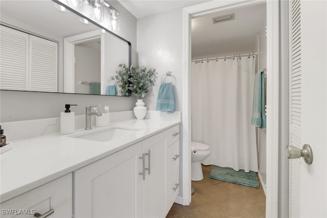 bathroom with tile patterned flooring, vanity, and toilet