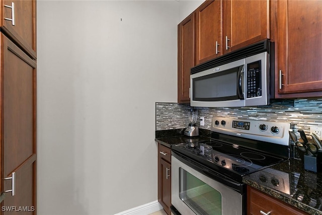 kitchen featuring decorative backsplash, dark stone countertops, and stainless steel appliances