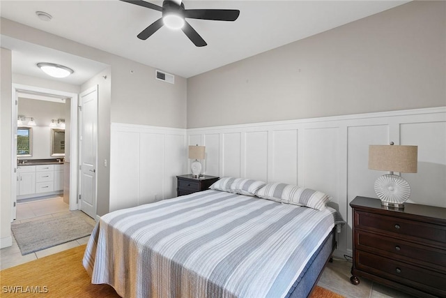 bedroom with ceiling fan, a closet, light tile patterned flooring, and ensuite bathroom