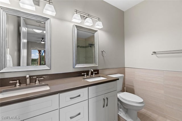 bathroom with vanity, toilet, tile walls, and ceiling fan