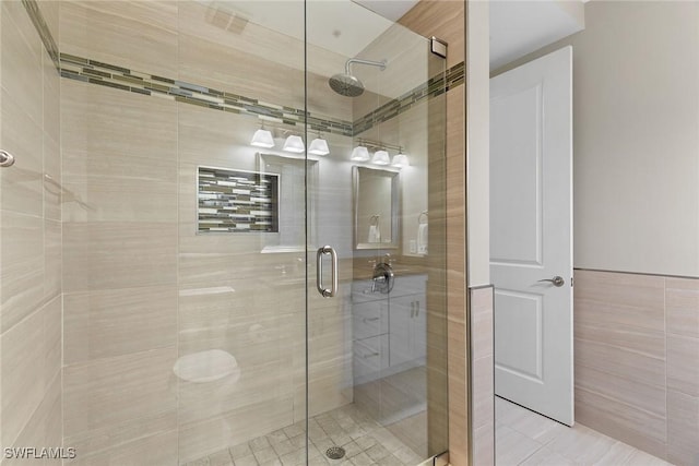 bathroom featuring tile patterned flooring, tile walls, and walk in shower