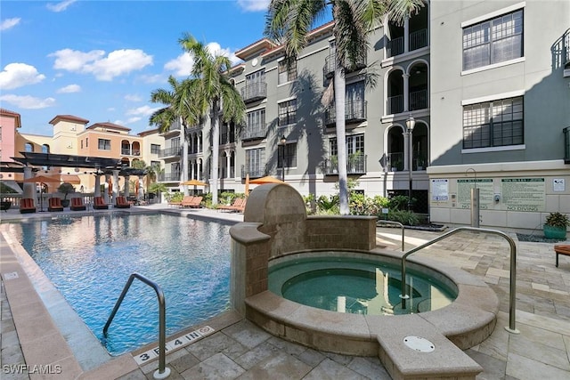 view of swimming pool with a pergola and a hot tub