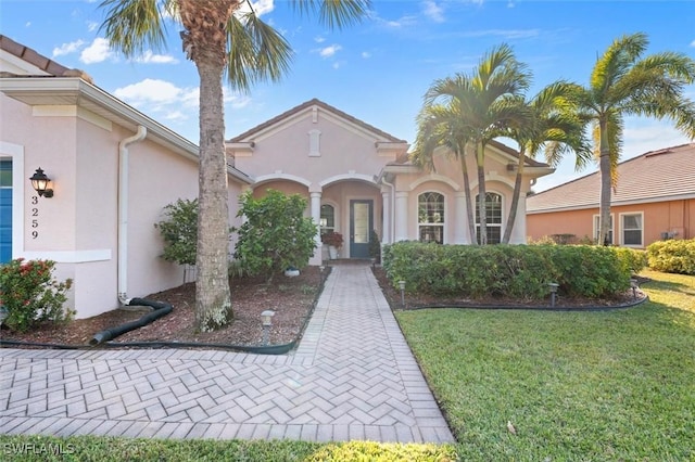 mediterranean / spanish-style home featuring a front yard