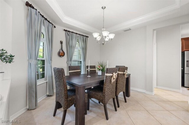 tiled dining space with a tray ceiling, ornamental molding, and a notable chandelier