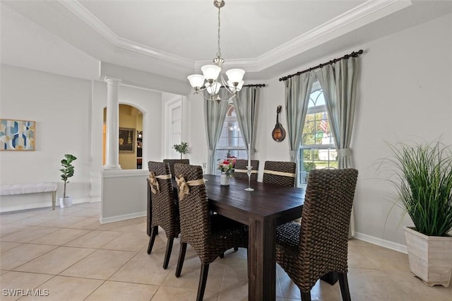 tiled dining area with a raised ceiling, ornate columns, and crown molding