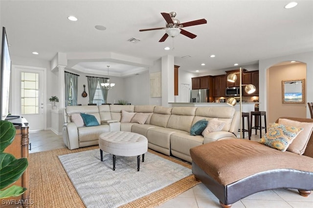 living room featuring arched walkways, recessed lighting, visible vents, light tile patterned flooring, and ceiling fan with notable chandelier