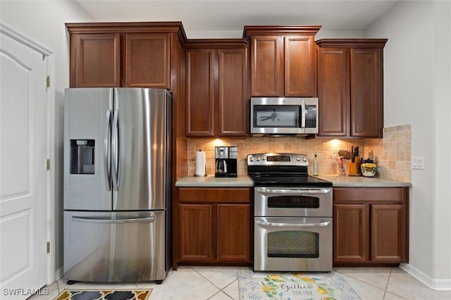 kitchen featuring decorative backsplash, light tile patterned floors, and stainless steel appliances