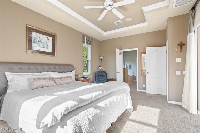 carpeted bedroom with a tray ceiling and ceiling fan