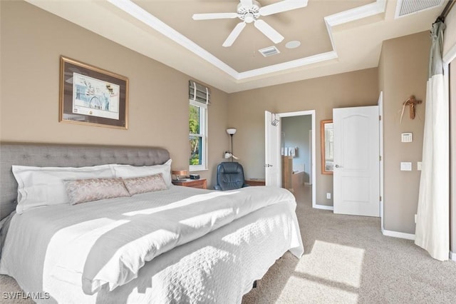 bedroom with a tray ceiling, visible vents, light colored carpet, and crown molding
