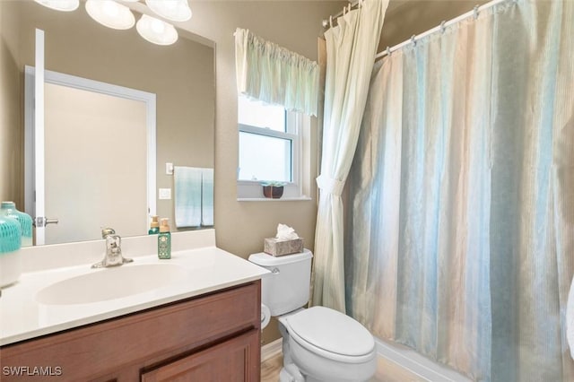 bathroom featuring toilet, curtained shower, and vanity
