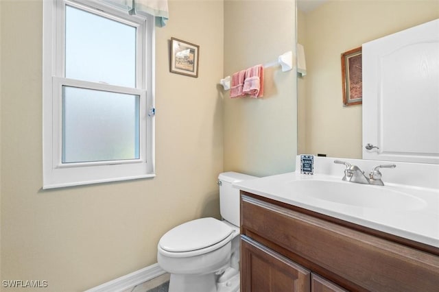 bathroom featuring vanity, toilet, and a healthy amount of sunlight