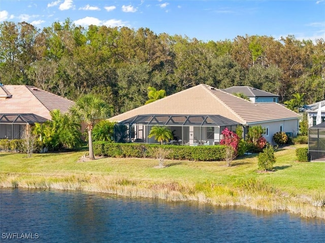 back of property featuring a yard, a water view, and glass enclosure