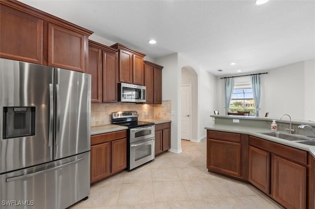 3259 Hampton Blvd, Alva, FL 33920 - kitchen featuring appliances with stainless steel finishes, arched walkways, backsplash, light tile patterned floors, and light countertops