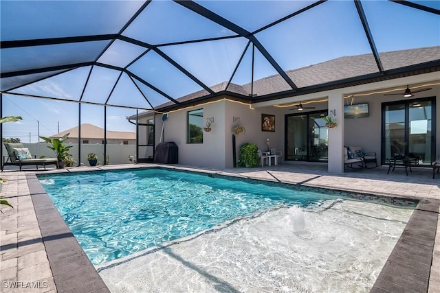 view of pool with glass enclosure, ceiling fan, and a patio area