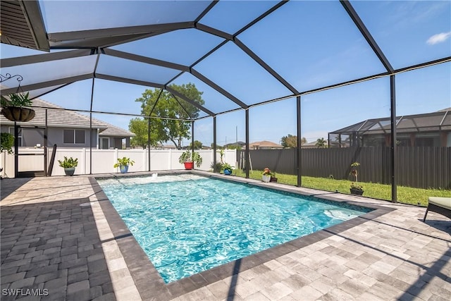 view of pool featuring glass enclosure and a patio