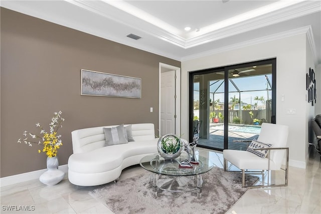 living room with a raised ceiling and crown molding