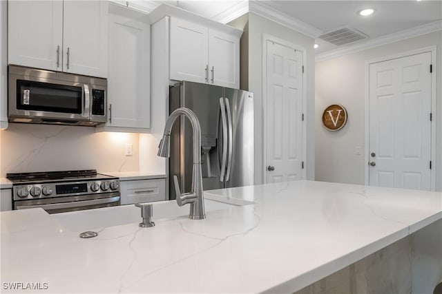 kitchen featuring white cabinets, stainless steel appliances, and light stone countertops