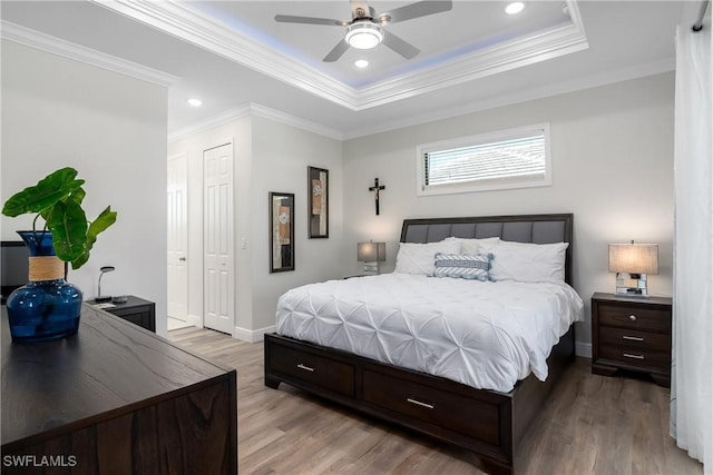 bedroom with light hardwood / wood-style floors, ceiling fan, and ornamental molding