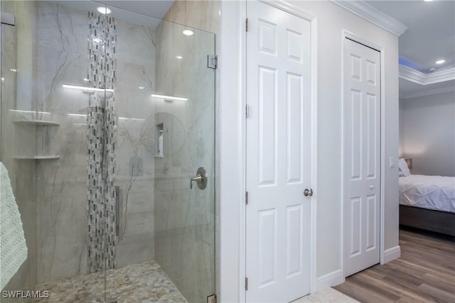 bathroom featuring hardwood / wood-style floors, an enclosed shower, and ornamental molding