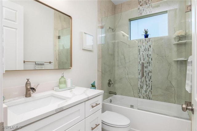 full bathroom featuring combined bath / shower with glass door, vanity, and toilet