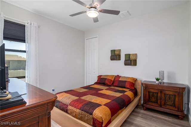 bedroom featuring hardwood / wood-style floors, ceiling fan, and a closet