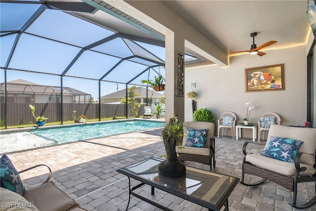 view of swimming pool with glass enclosure, ceiling fan, and a patio area