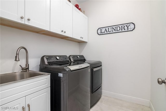 washroom featuring cabinets, separate washer and dryer, sink, and light tile patterned floors