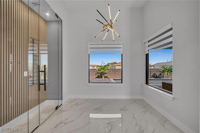 unfurnished room featuring a healthy amount of sunlight and a notable chandelier