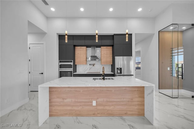 kitchen with stainless steel appliances, light stone countertops, hanging light fixtures, and wall chimney range hood