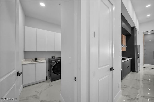 laundry room featuring cabinets, washer / dryer, and sink