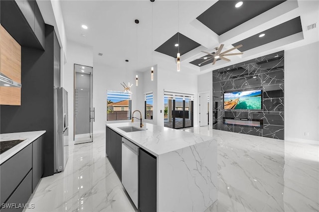 kitchen with light stone countertops, hanging light fixtures, dishwasher, and sink