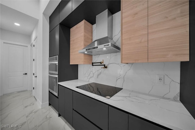 kitchen featuring wall chimney exhaust hood, stainless steel double oven, light stone counters, backsplash, and black electric cooktop